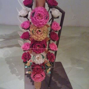Vela de cera cubierta con flores hechas de cera de colores